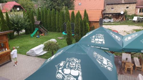 a blue umbrella with two dogs on it in a backyard at Penzión pri studničke Omastiná in Omastiná