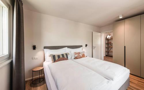 a bedroom with a large white bed and a window at apartments55 in Bressanone