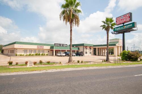 una tienda con palmeras frente a una calle en Best Price Motel & Suites en Orange
