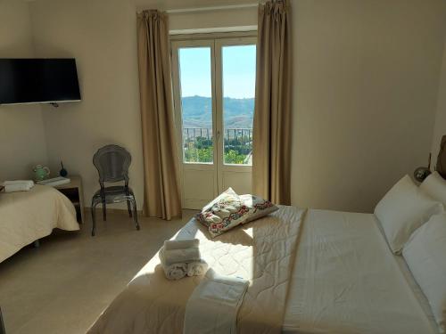 een slaapkamer met een bed en een groot raam bij Masseria Torre Saracena in Agrigento