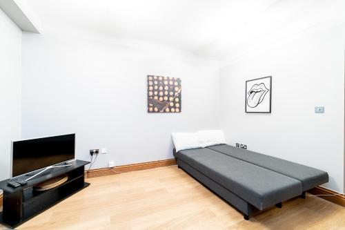 a bedroom with a bed and a flat screen tv at (St' Paul Cathedral) London Studio Apartment in London