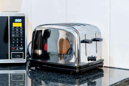 a toaster sitting on a counter next to a microwave at (St' Paul Cathedral) London Studio Apartment in London
