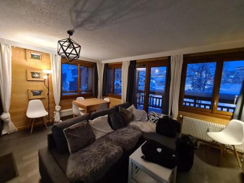 a living room with a couch and some windows at Edelweiss 2100 in Tignes