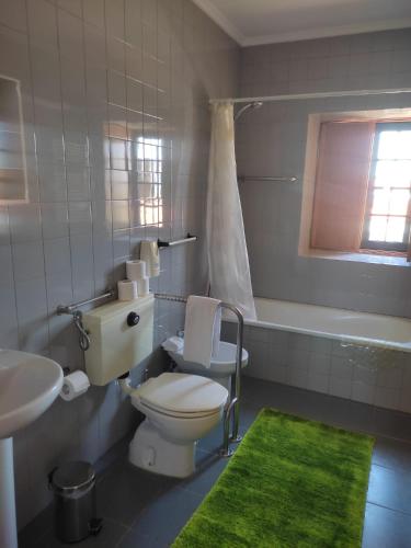 a bathroom with a toilet and a sink and a tub at Guesthouse Casa das Abegoarias in Celorico de Basto