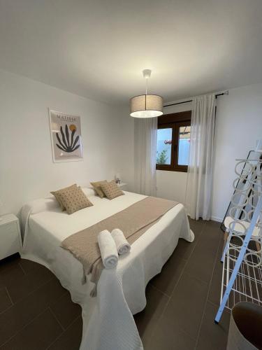 Ein weißes Schlafzimmer mit einem großen Bett und weißer Bettwäsche. in der Unterkunft Coello 31 in Jaén