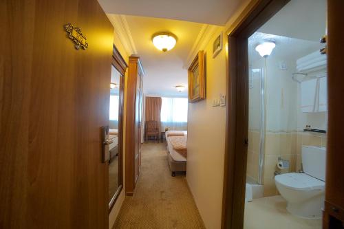 - un couloir d'une salle de bains pourvue de toilettes et d'un lavabo dans l'établissement Grand Unal Hotel, à Istanbul