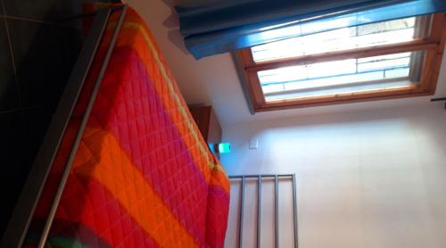 a bedroom with a rainbow bed and a window at B&B Des Artistes in Borzano