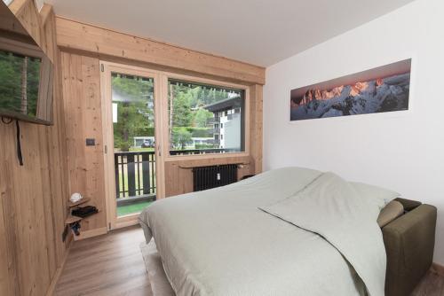 sypialnia z łóżkiem i dużym oknem w obiekcie Charmant Studio tout confort au Brévent-Chamonix w Chamonix-Mont-Blanc