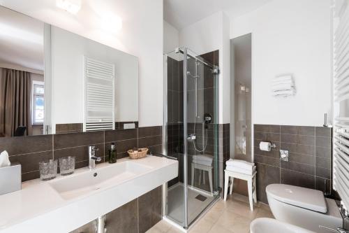 a bathroom with a sink and a shower and a toilet at Classic Hotel Am Stetteneck in Ortisei