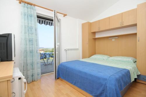 - une chambre avec un lit, une télévision et une fenêtre dans l'établissement Apartments and rooms with a swimming pool Babici, Umag - 3046, à Umag