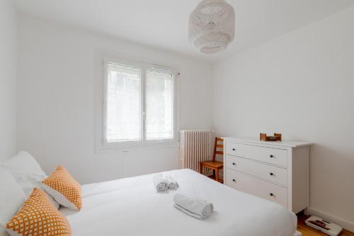 1 dormitorio con 1 cama blanca, vestidor y ventana en Appartement lumineux centre de Saint-Nazaire en Saint-Nazaire