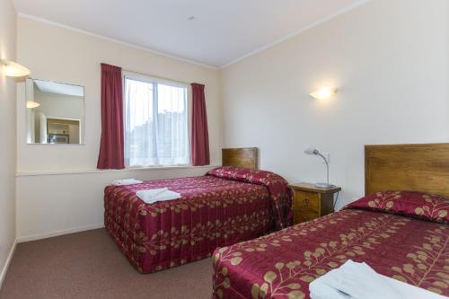 a hotel room with two beds and a window at Fernhill Motor Lodge in Lower Hutt
