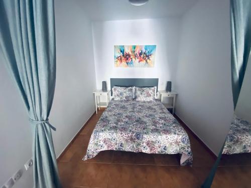 una camera da letto con un letto e un dipinto sul muro di VV Estrella a Puerto de Mogán