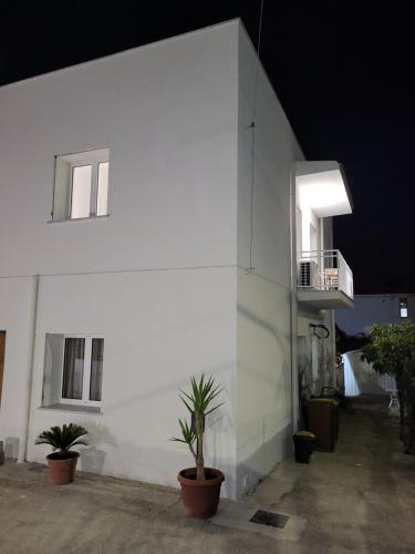 a white building with potted plants in front of it at Casa Villaggio Pirandello in Agrigento