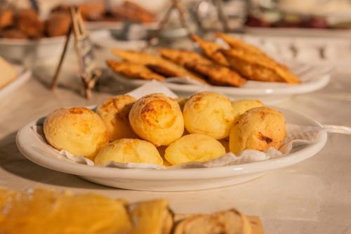 a plate of potatoes on a table with other plates of food at Pousada Tapera in Penedo