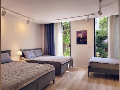 1 dormitorio con 2 camas y ventana en Gallery Family Hotel en Mokpo