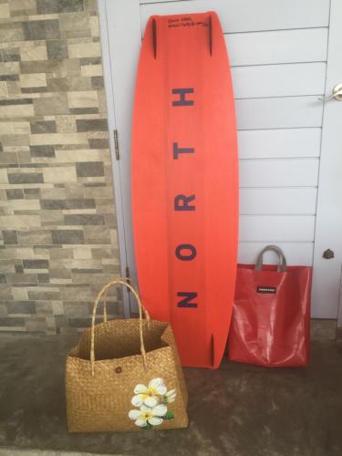a surfboard and two bags next to a door at BC Summer Beach in Pran Buri