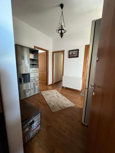 a living room with a hard wood floor and a refrigerator at Casa Mugur in Sinaia