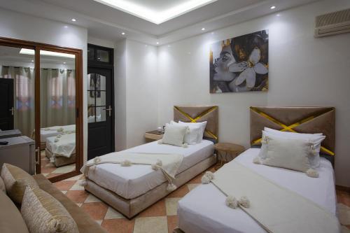 uma sala de estar com duas camas e um sofá em RIAD DOUIRTNA em Marrakech