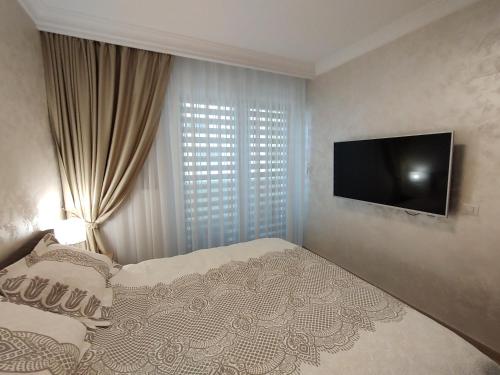a bedroom with a bed and a flat screen tv at Decebal Premium Confort in Craiova