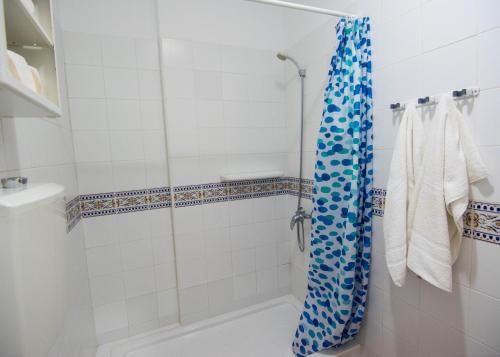 W łazience znajduje się prysznic z niebieską zasłoną prysznicową. w obiekcie Apartamentos Alcalá - Tenerife w mieście Alcalá
