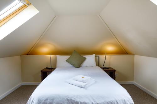 a bedroom with a white bed with two lamps at Abbeyfield Lodge in Stockton-on-Tees