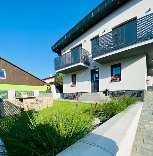 a house with a balcony on the side of it at Apartmány TAMKA in Vrbov