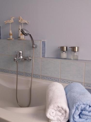een badkamer met een bad en handdoeken. bij VELOCIPEDE OUDENAARDE vakantieverblijf 6 pers ADULTS ONLY in Oudenaarde