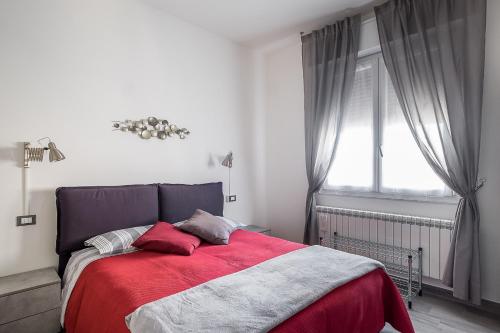 a bedroom with a bed with a red blanket and a window at Appartamento a Piazza dell'Unità by Wonderful Italy in Bologna