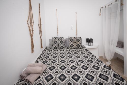 a bedroom with a black and white bed with pillows at Eris Studios in Adamas