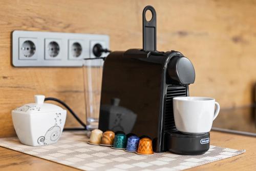 a coffee maker and a cup on a table at Wienerberg-Apartments in Vienna