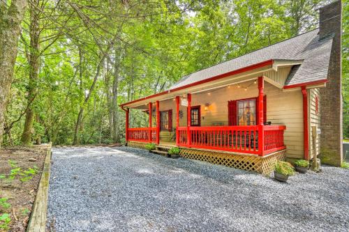 a home with a red front porch and trees at Cozy Creekside Mountain Escape with Hot Tub! in Sautee Nacoochee