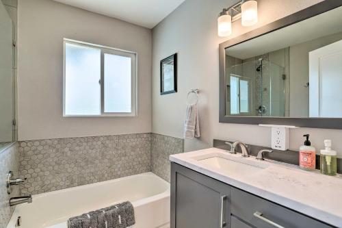 Un baño con lavabo, bañera y espejo. en Palm Springs Retreat with Private Pool and Spa!, en Palm Springs