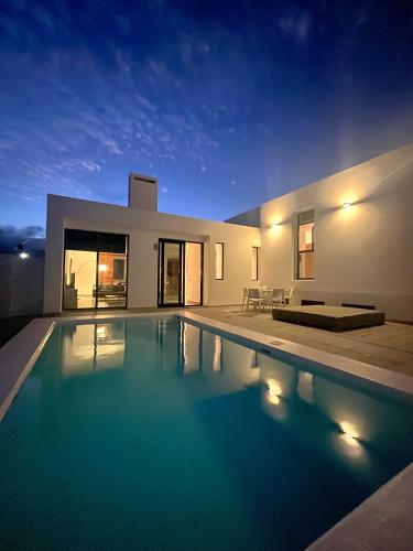 a swimming pool in front of a house at night at Casa Blanca Teguise in Teguise