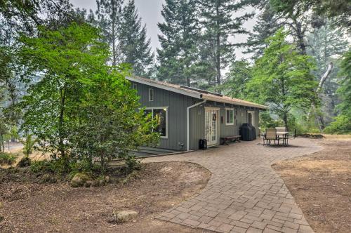 a green house with a patio in the woods at Step-Free Hawkins Bar Home Near Trinity River in Salyer