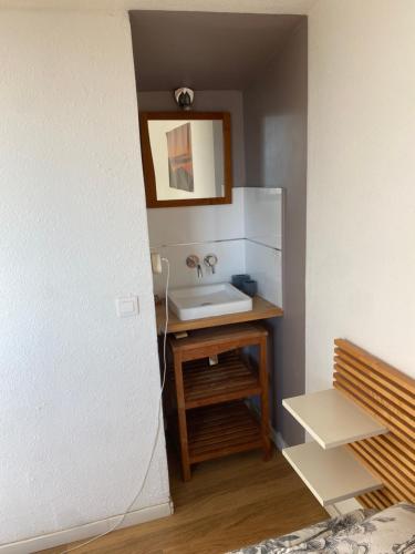 W łazience znajduje się umywalka i lustro. w obiekcie Chambre chez l habitant 2 nuit maximum w mieście Porticcio