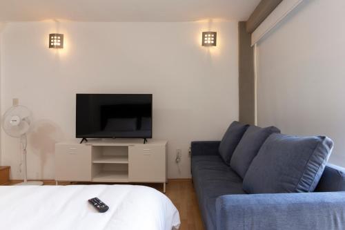 a living room with a couch and a flat screen tv at Prosperidad by HomiRent in Mexico City
