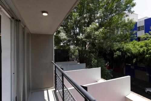 a balcony of a building with white stairs and trees at Prosperidad by HomiRent in Mexico City