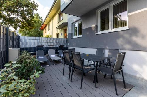 a patio with chairs and tables and a fence at Wienerberg-Apartments in Vienna