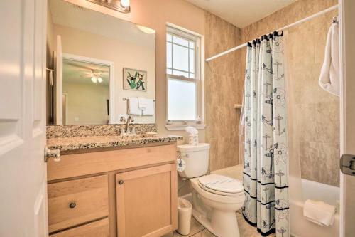 een badkamer met een toilet, een wastafel en een spiegel bij St Augustine Island Cottage - Walk to Beach in St. Augustine