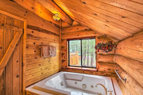 uma banheira num quarto de madeira com uma janela em Tranquil Mountain Cabin with Game Room and Fireplace! em Greer
