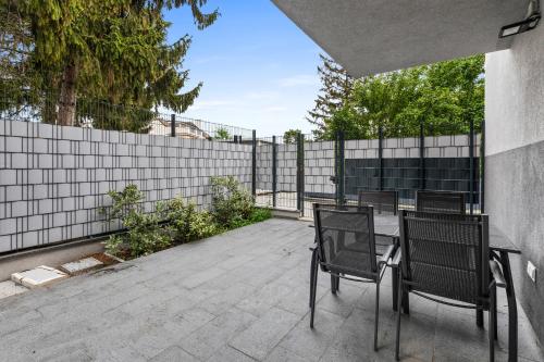 a patio with chairs and a table and a fence at Wienerberg-Apartments in Vienna