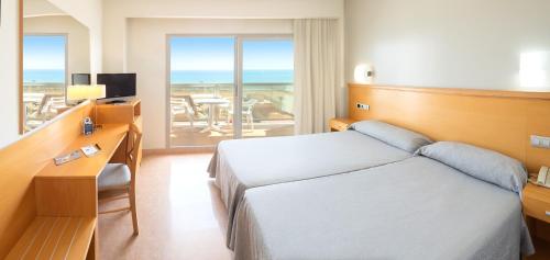 a hotel room with a bed and a desk and a window at Hotel RH Gij&oacute;n & Spa in Gand&iacute;a