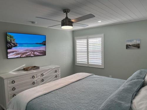 a bedroom with a bed and a flat screen tv at Sunset Connection - Gulf Place in Holmes Beach