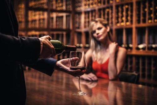 a man pouring a glass of wine in front of a woman at Los Angeles Athletic Club in Los Angeles