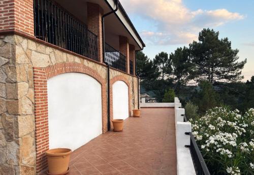 a brick building with two white garage doors and flowers at Casa Paco de Gredos in Arenas de San Pedro