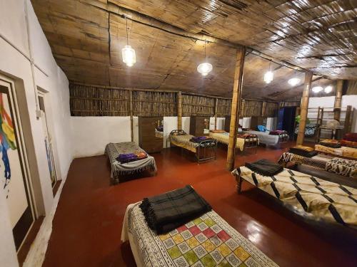 a room with several beds and tables in it at StoneAge Resort Sakleshpur in Sakleshpur