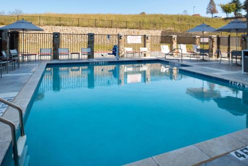 a large blue swimming pool with chairs and umbrellas at Hyatt Place Dallas/Rockwall in Rockwall