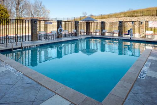 a swimming pool with blue water in front of a fence at Hyatt Place Dallas/Rockwall in Rockwall