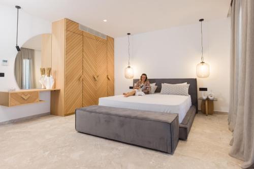 a woman sitting on a bed in a bedroom at Milestones Naxos in Naxos Chora